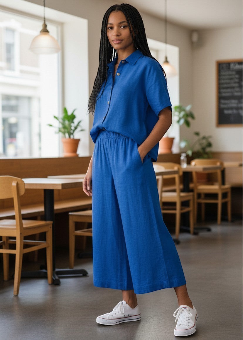 Antique Rose Boutique blue linen viscose wide-leg culottes with elastic waistband worn by a model in a cafe.