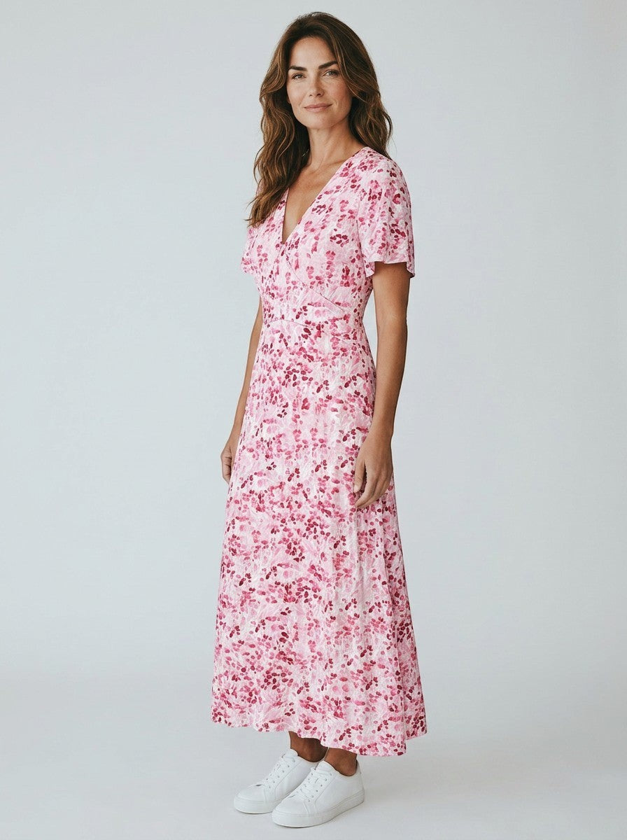 Antique Rose Boutique floral print midi dress with flutter sleeves and V-neckline worn by a woman with white sneakers.