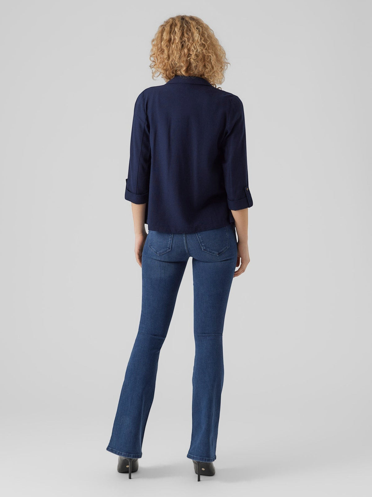 Antique Rose Boutique navy blue loose blazer with 3/4 sleeves in a viscose linen blend, worn with blue flared jeans.