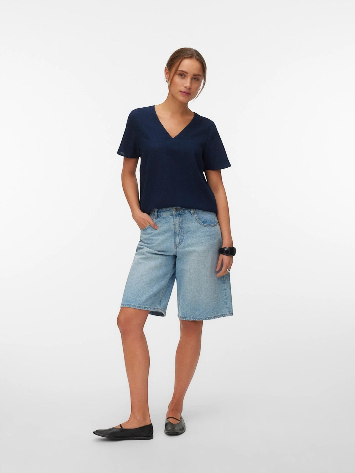 Antique Rose Boutique navy blue linen-mix V-neck top worn by a model with denim shorts and black flats.