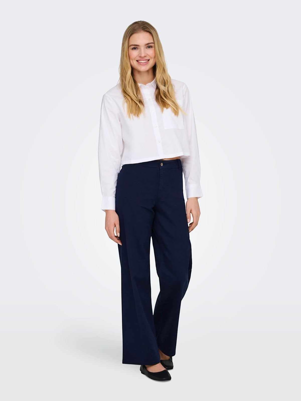 Antique Rose Boutique model wearing navy blue high-waisted wide-leg cotton mix denim trousers with a white shirt