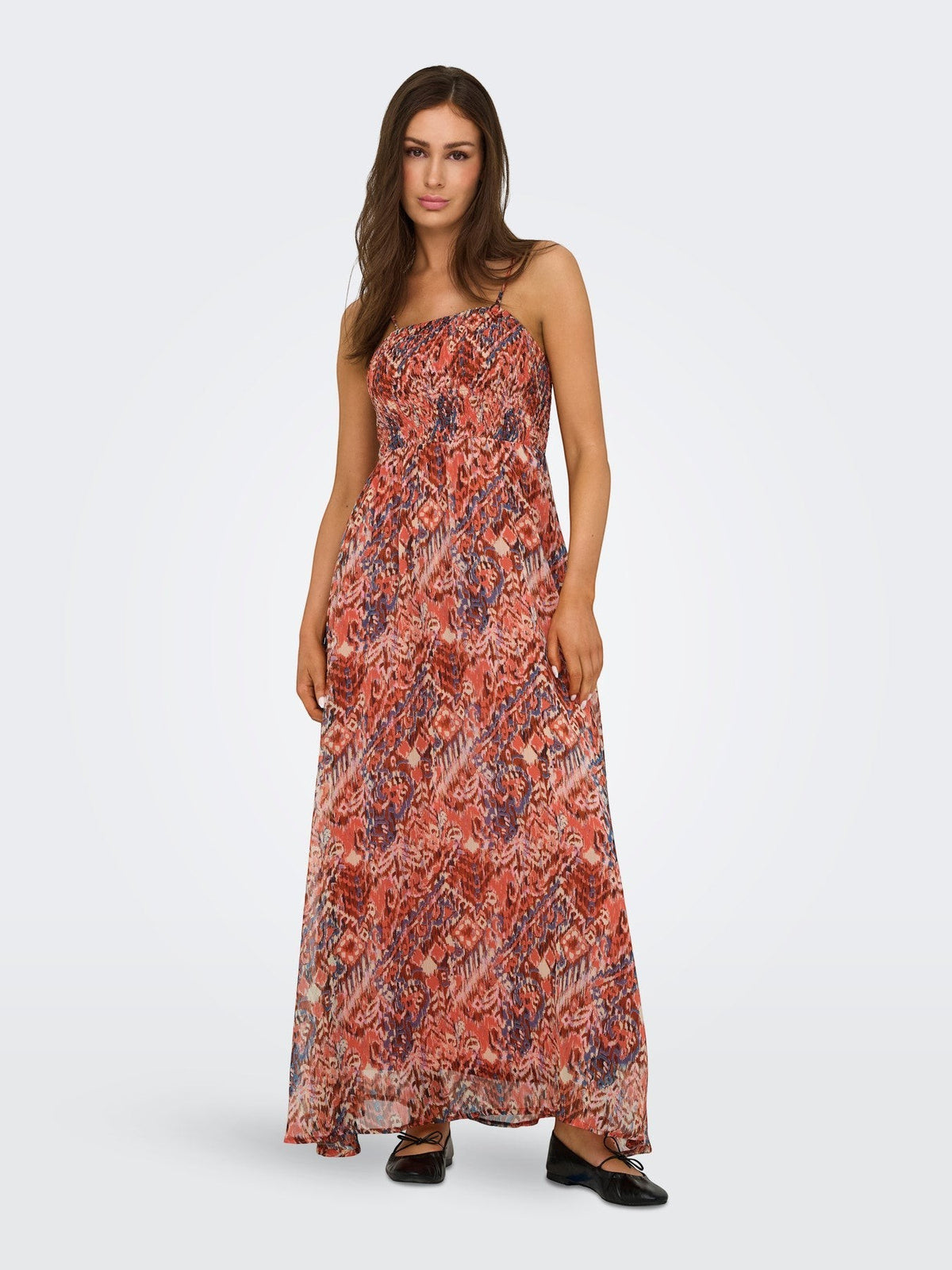 Antique Rose Boutique orange patterned sleeveless maxi dress with a smocked bodice and V-neckline worn by a model.