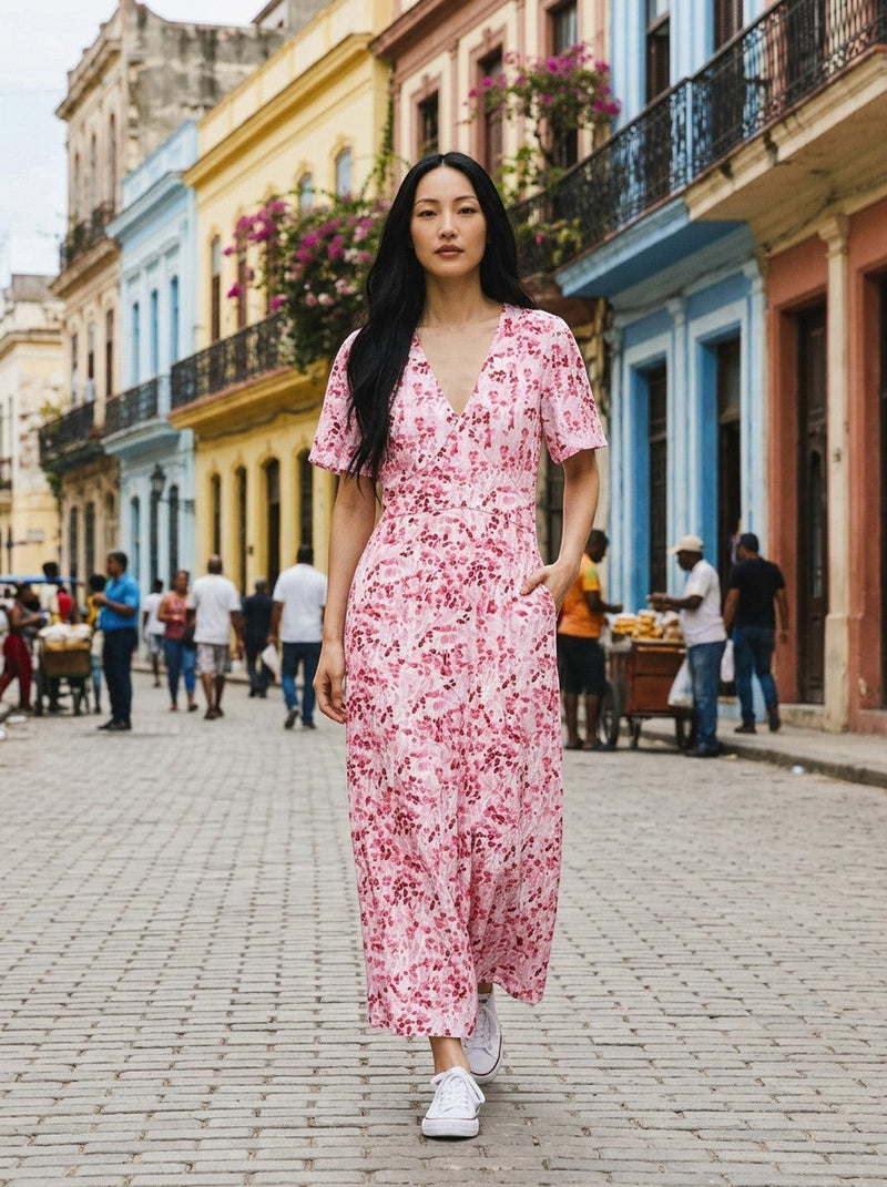 Antique Rose Boutique pink floral print midi dress with flutter sleeves and V-neckline worn by a woman on a city street.