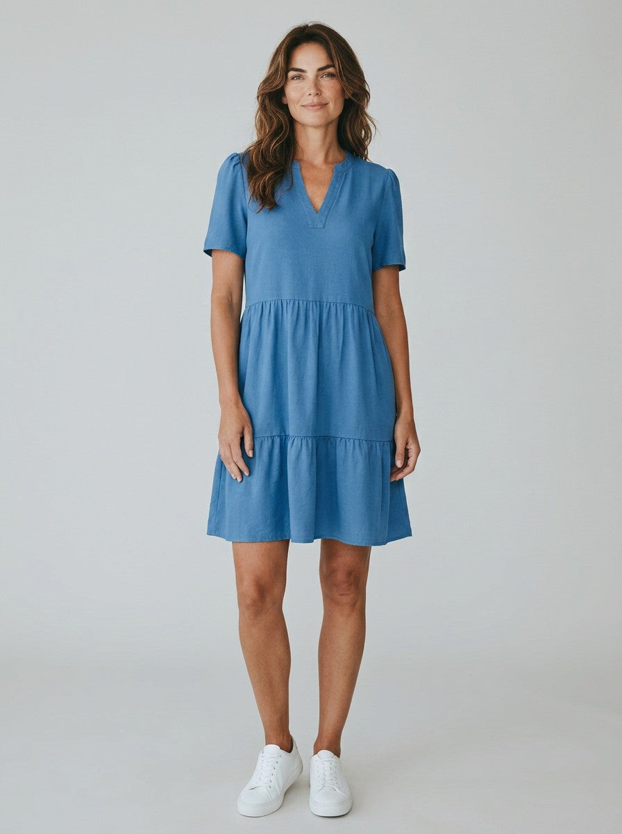 Antique Rose Boutique Riviera Denim Blue linen mix short tiered dress with V-neck and short sleeves on a model