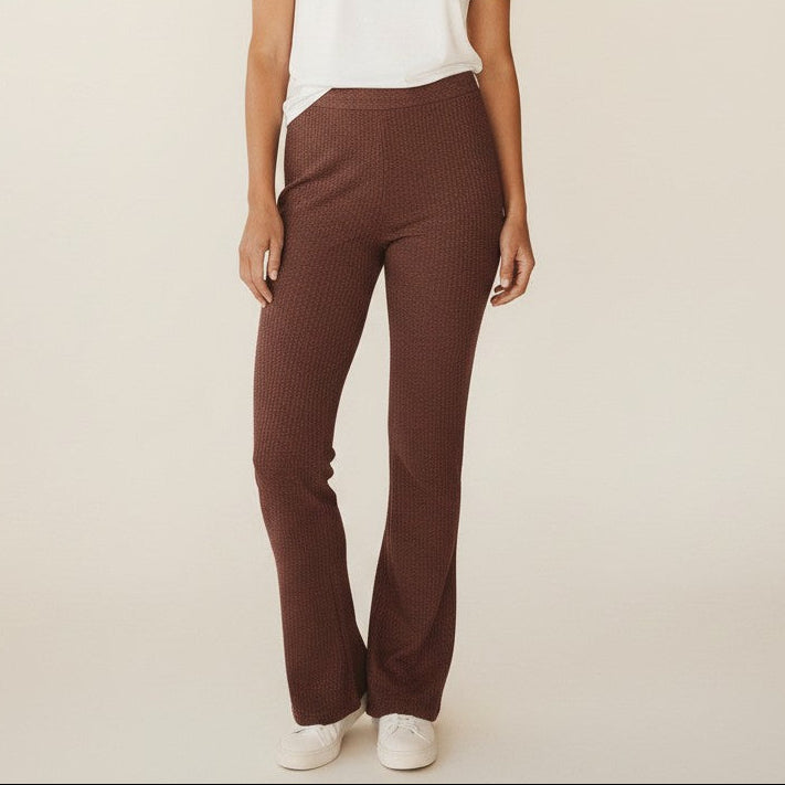 Antique Rose Boutique Vero Moda rust red stretch flared trousers worn by a woman with a white t-shirt and sneakers