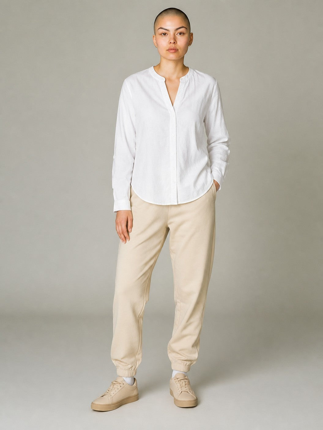 Antique Rose Boutique white linen blend V-neck shirt with long sleeves and button cuffs worn by a model.