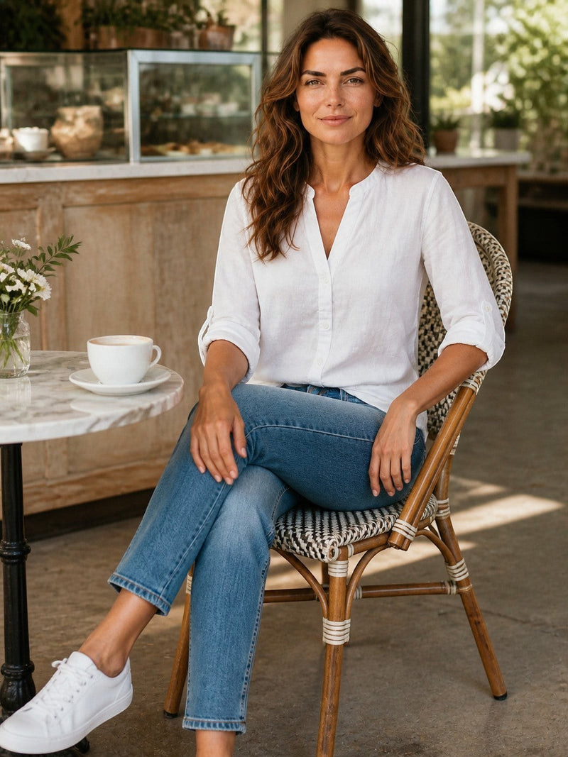 Antique Rose Boutique white linen blend V-neck shirt with long sleeves worn by a woman sitting in a cafe