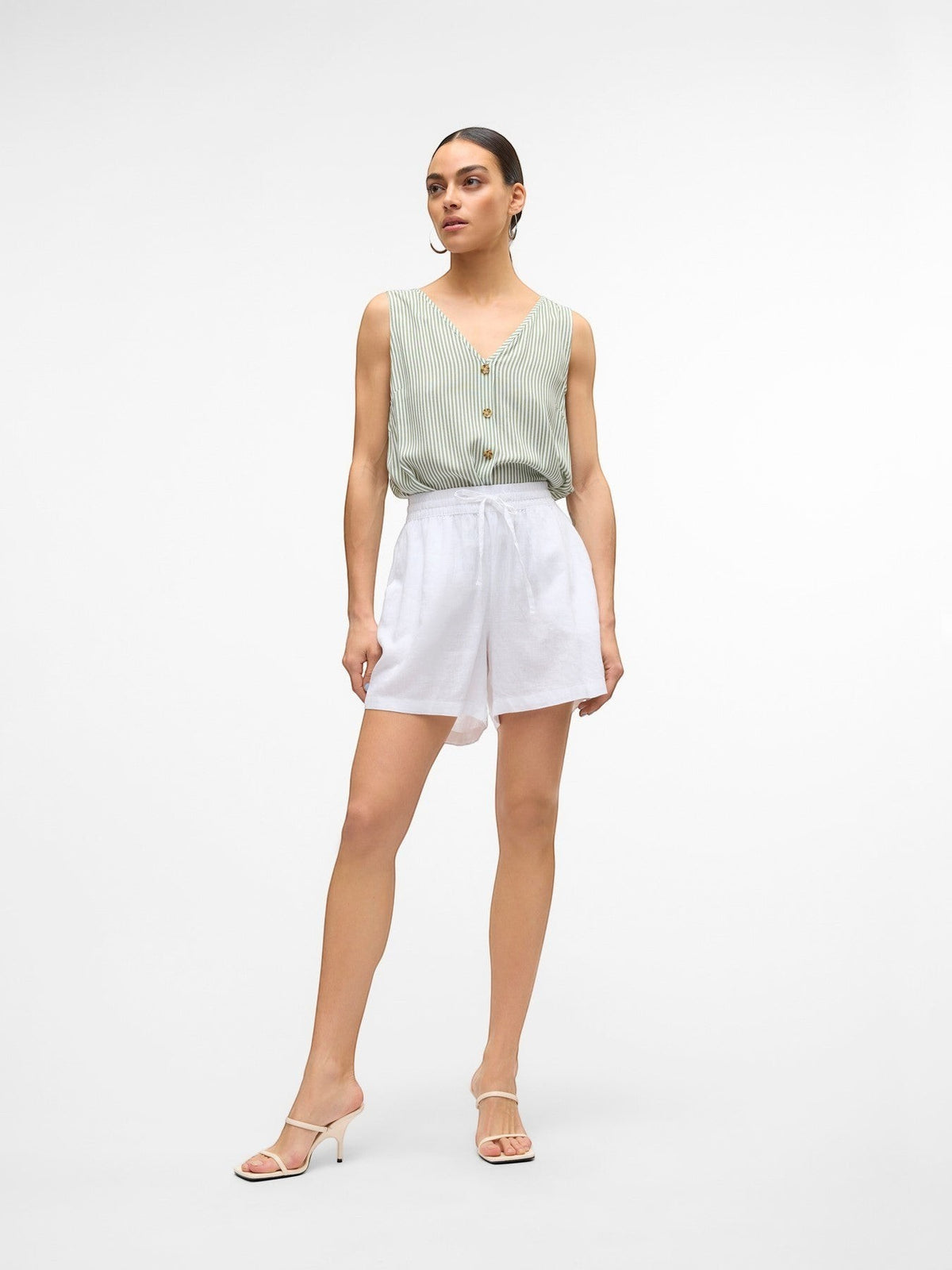 Antique Rose Boutique white linen blend shorts with a drawstring waist worn by a model with a striped top