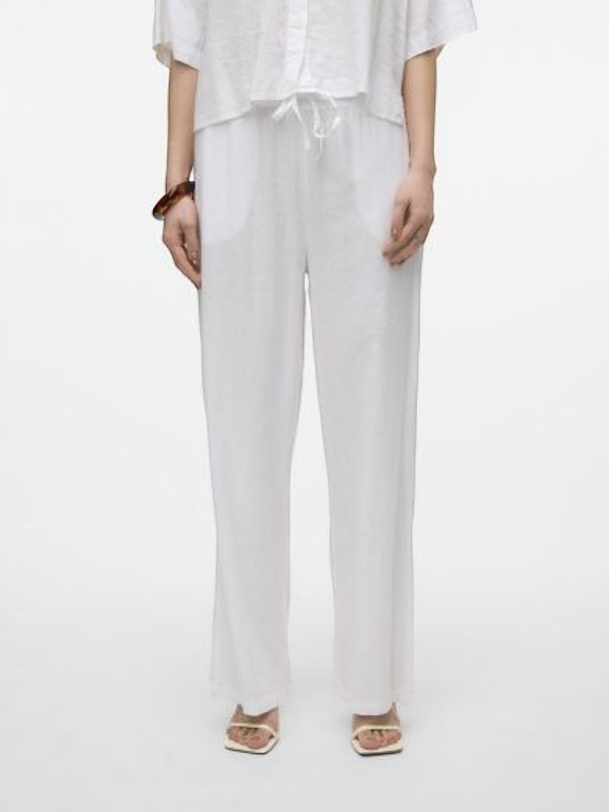 Antique Rose Boutique white linen wide-leg trousers with a drawstring waist worn with strappy sandals