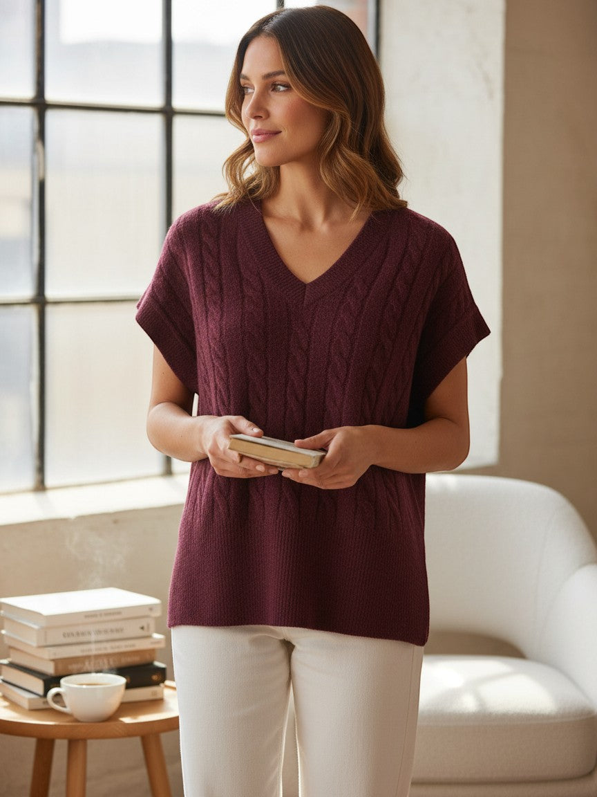 Antique Rose Boutique fig wine red cable knit V-neck sleeveless vest worn by a woman in a bright room