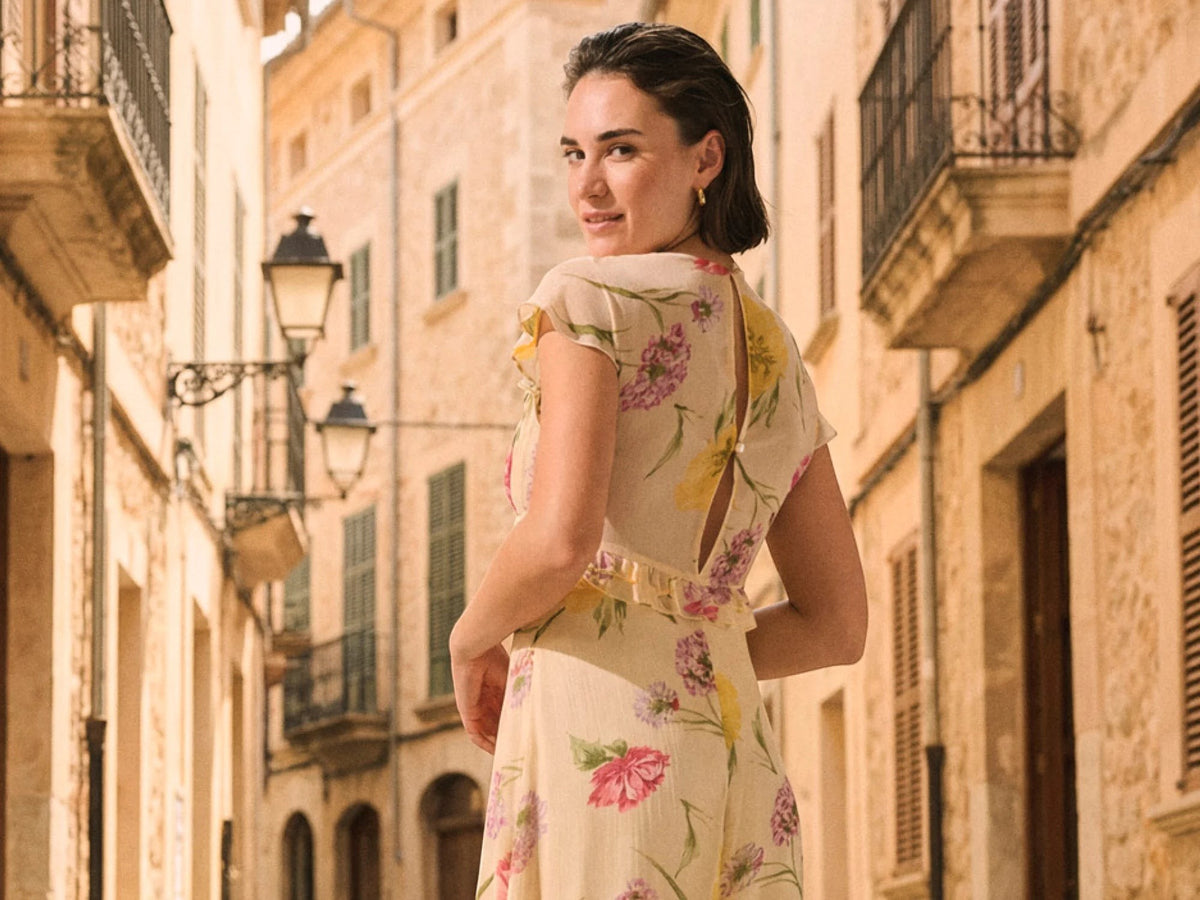 Antique Rose Boutique yellow floral chiffon maxi dress with short sleeves and frill details on a woman outdoors